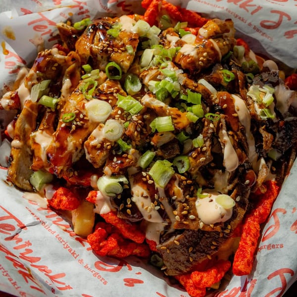 Teriyaki J's teriyaki chicken and beef over fries and hot Cheetos, drizzled with sauce and green onions.