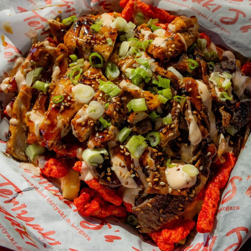 Teriyaki J's teriyaki chicken and beef over fries and hot Cheetos, drizzled with sauce and green onions.