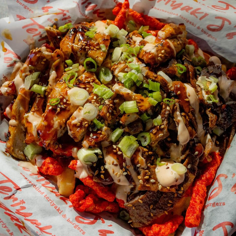 Teriyaki J's teriyaki chicken and beef over fries with hot Cheetos, sauce, sesame seeds, and green onions.