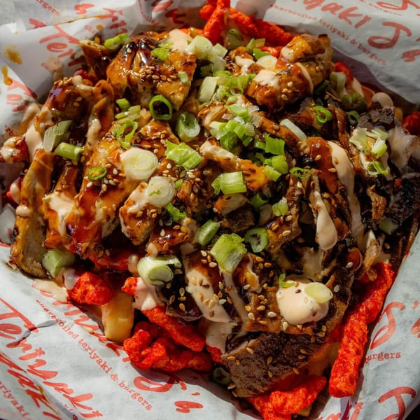 Teriyaki J's teriyaki chicken and beef over fries and hot Cheetos, drizzled with sauce and green onions.