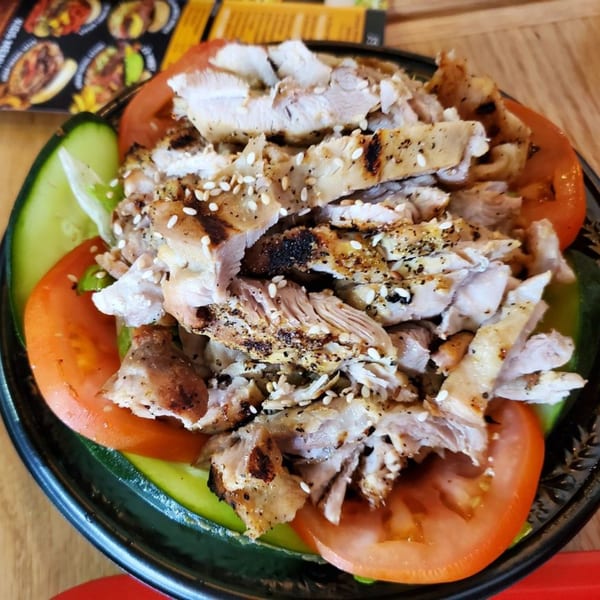 Teriyaki J's chicken salad with grilled chicken, sesame seeds, tomatoes, and cucumbers.